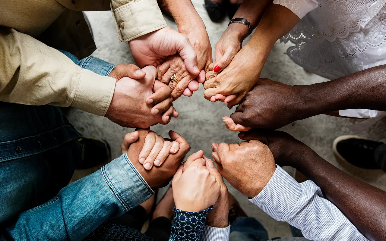 Diverse group of people holding hands in unity, representing AfCAA’s “50 Ambassadors of Peace Fund” campaign to support accountability across Africa